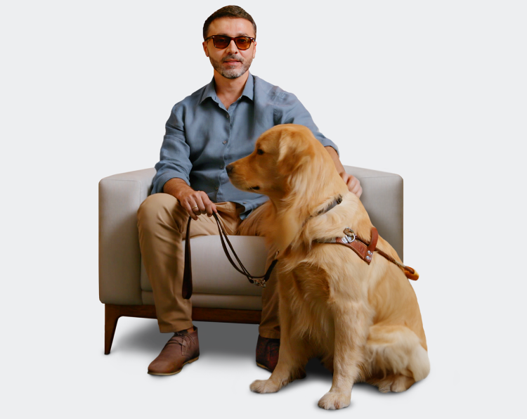 Vision-impaired man with an inherited retinal disease (IRD) sitting with guide dog