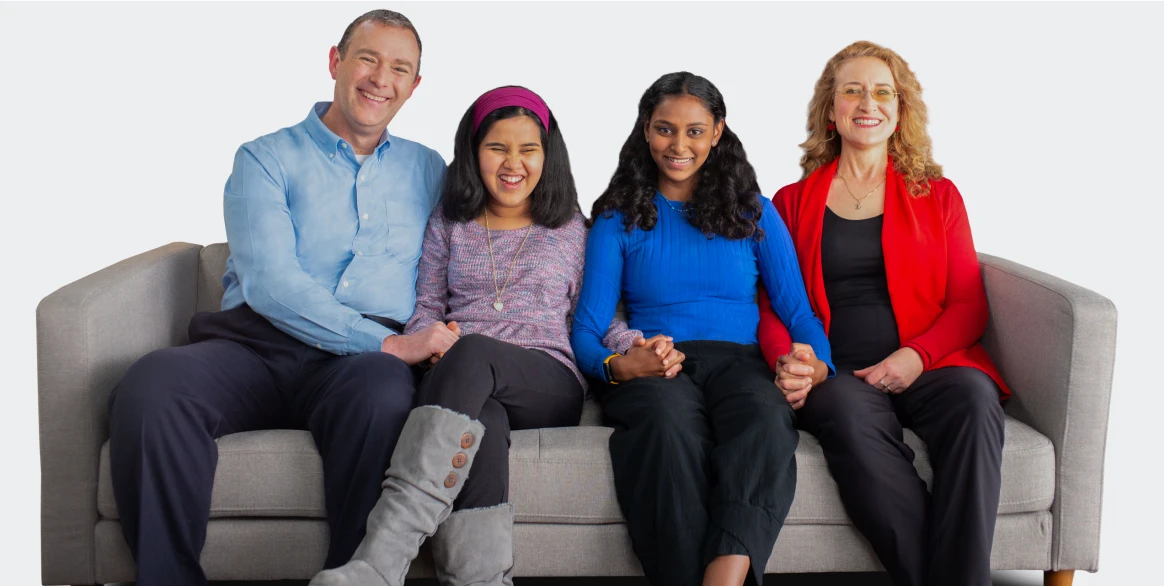 Lisa, woman with an inherited retinal disease (IRD), sitting on a couch with her family